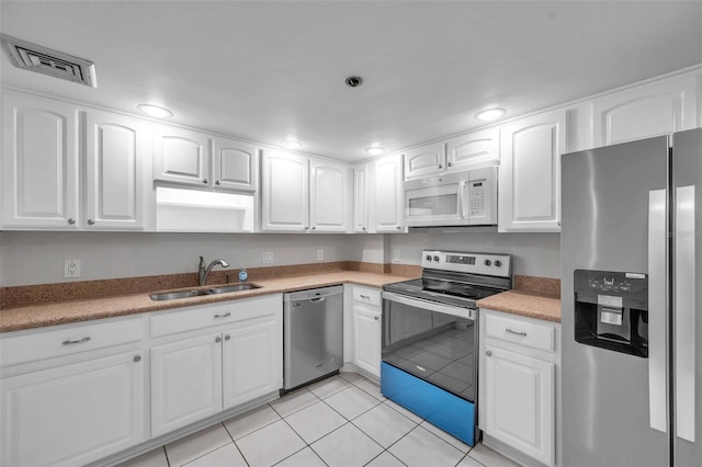 kitchen featuring sink, white cabinetry, stainless steel appliances, and light tile patterned floors