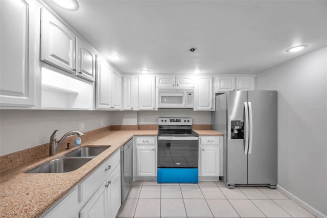 kitchen featuring sink, light tile patterned floors, light stone counters, white cabinets, and appliances with stainless steel finishes