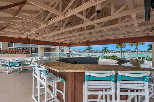 view of patio / terrace featuring a water view and exterior bar