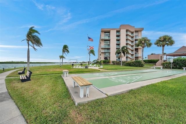 view of home's community with a lawn and a water view