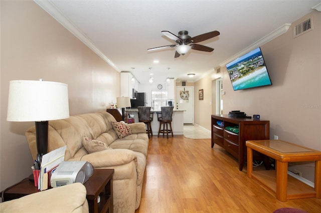 living room featuring crown molding, ceiling fan, and light hardwood / wood-style floors