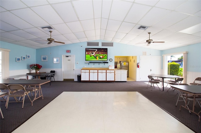 carpeted living room featuring ceiling fan and a drop ceiling