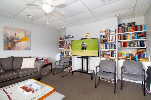 interior space with carpet floors, a drop ceiling, and ceiling fan