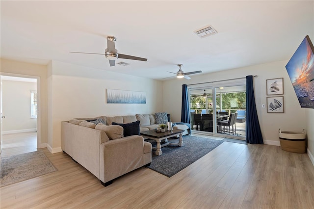 living room with ceiling fan and light hardwood / wood-style flooring