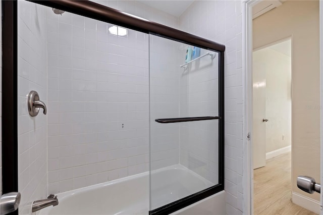 bathroom with enclosed tub / shower combo and hardwood / wood-style floors