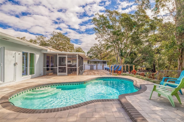 view of swimming pool with a patio and a sunroom