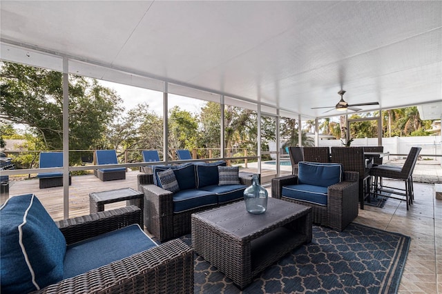 sunroom featuring ceiling fan and plenty of natural light