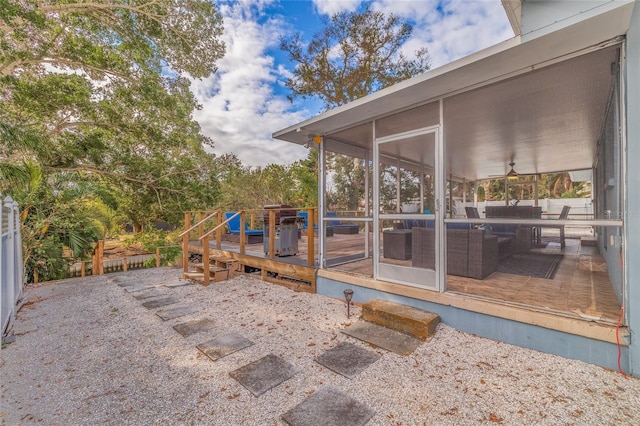 view of patio with ceiling fan, a deck, outdoor lounge area, and a sunroom