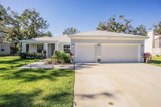 ranch-style house featuring a garage and a front lawn