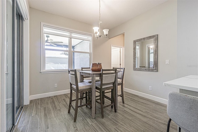 dining space featuring hardwood / wood-style flooring and a notable chandelier