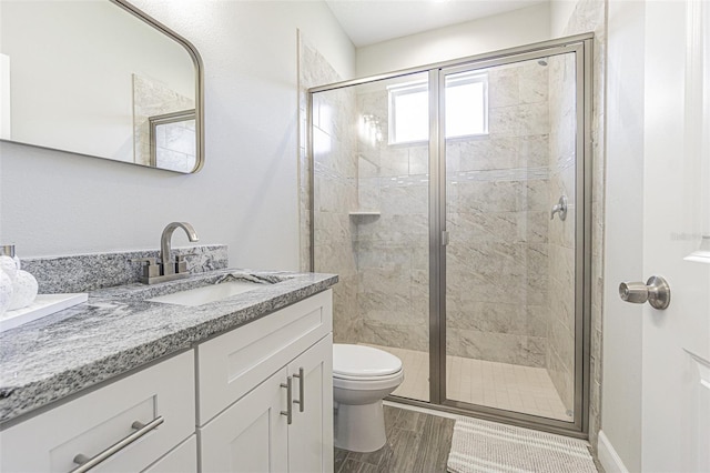 bathroom with vanity, a shower with shower door, and toilet