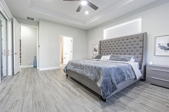 bedroom with a raised ceiling, ceiling fan, light hardwood / wood-style flooring, and crown molding