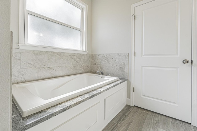 bathroom with plenty of natural light and a tub