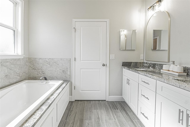 bathroom with a washtub and vanity