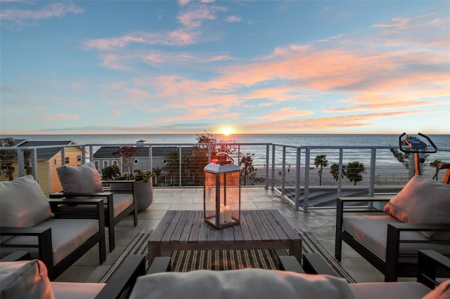 deck at dusk with an outdoor hangout area and a water view