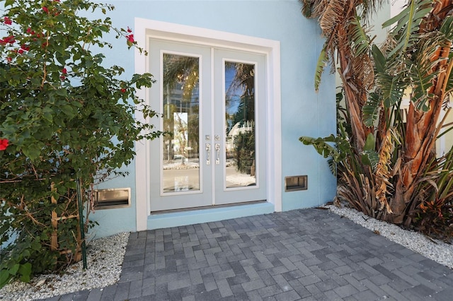 property entrance featuring french doors and stucco siding