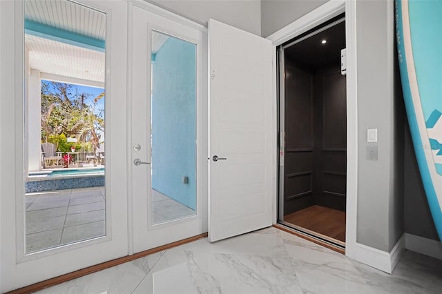 doorway to outside with french doors, baseboards, and marble finish floor