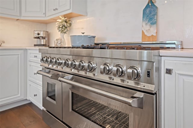 kitchen featuring dark wood-style floors, white cabinets, double oven range, and light countertops