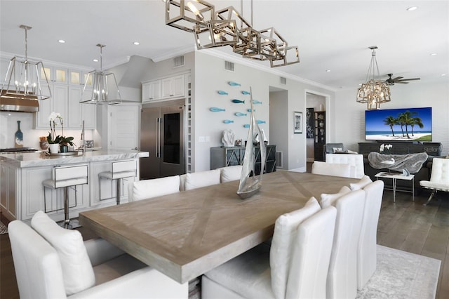 dining space featuring visible vents, wood finished floors, a chandelier, and crown molding