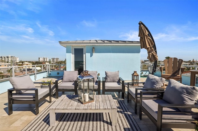 view of patio with outdoor lounge area, a view of city, and a balcony