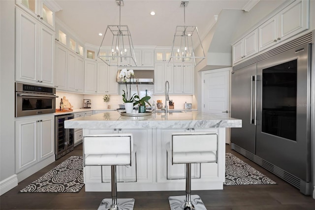 kitchen featuring a sink, white cabinets, beverage cooler, and stainless steel appliances