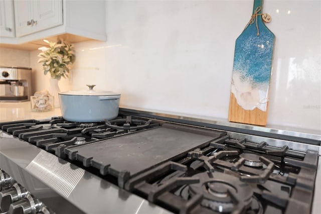 details with white cabinets, gas stove, and stovetop