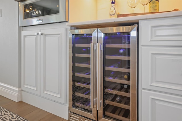 room details with wine cooler, a dry bar, and wood finished floors