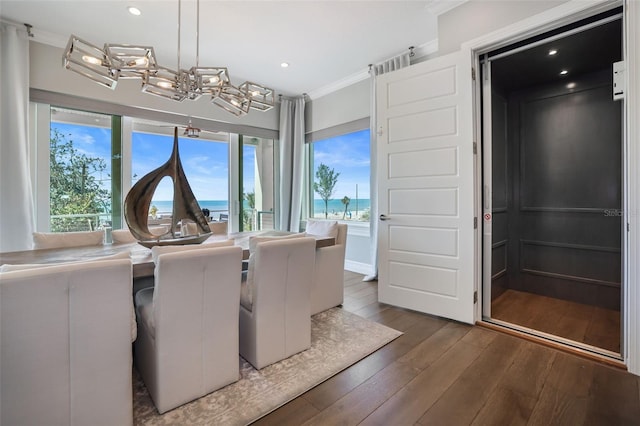 dining space with hardwood / wood-style floors, a notable chandelier, a healthy amount of sunlight, and ornamental molding