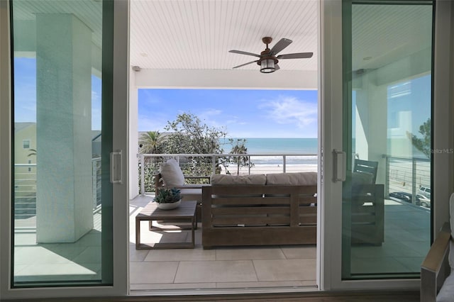 exterior space with a view of the beach, a ceiling fan, and a water view