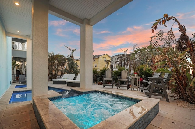 view of pool with an outdoor living space, a patio, an in ground hot tub, and fence