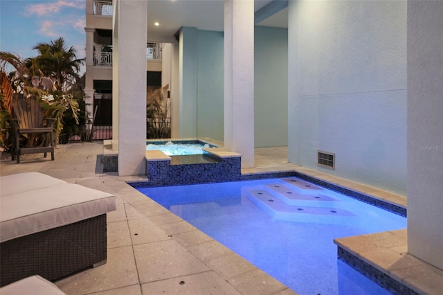 outdoor pool featuring an in ground hot tub and a patio area