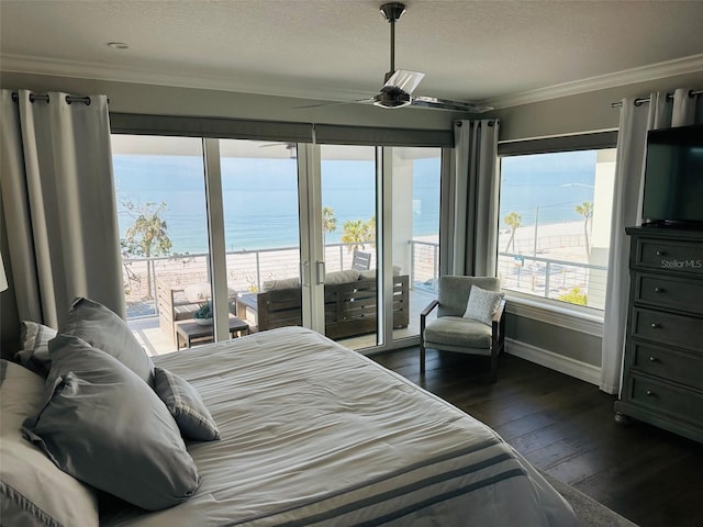 bedroom featuring dark wood-style floors, baseboards, a textured ceiling, crown molding, and access to outside