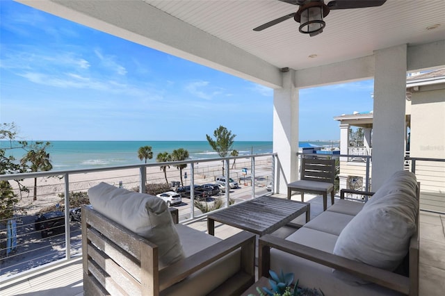 balcony featuring an outdoor living space, a ceiling fan, a water view, and a view of the beach