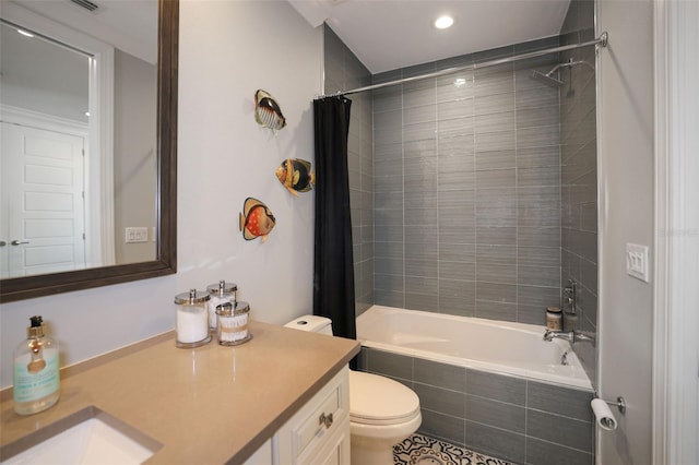 bathroom with vanity, toilet, and tiled shower / bath