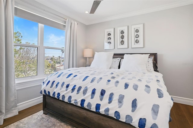 bedroom with crown molding, baseboards, dark wood-style flooring, and ceiling fan