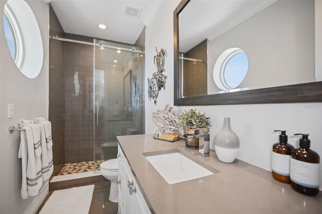 bathroom with visible vents, vanity, a shower stall, and toilet