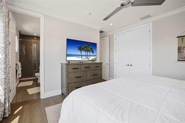 bedroom with visible vents, baseboards, dark wood finished floors, and ornamental molding