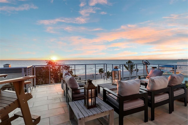 patio terrace at dusk featuring an outdoor living space and a water view