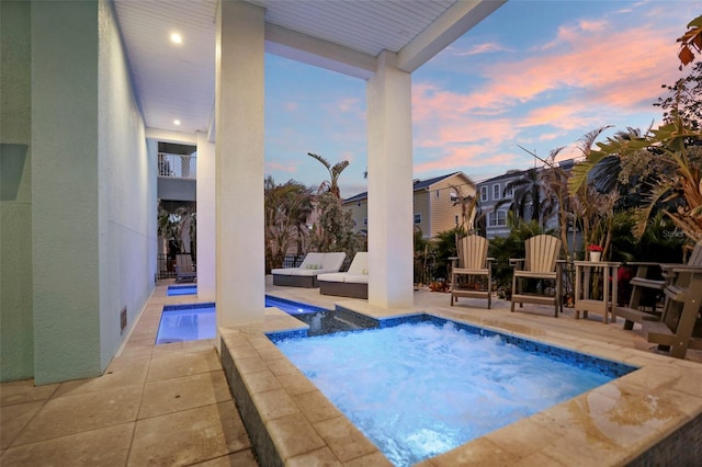 pool with an outdoor living space and a patio