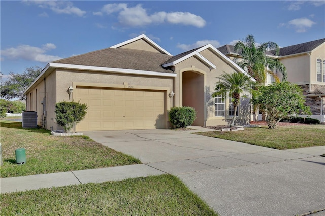 view of front of property featuring a garage, a front lawn, and central air condition unit