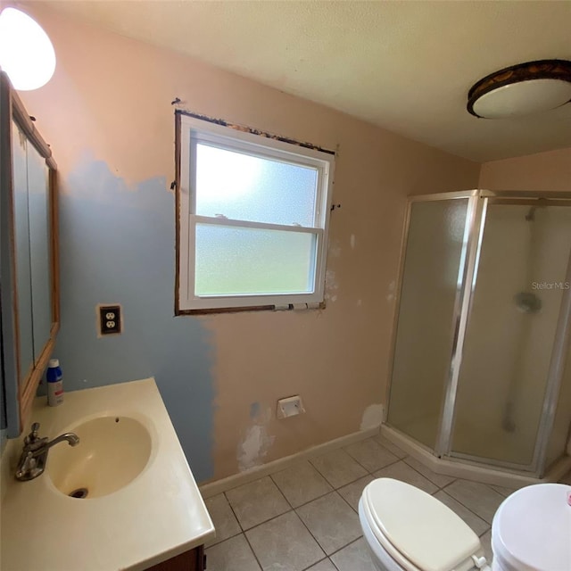 bathroom with toilet, vanity, tile patterned floors, and walk in shower