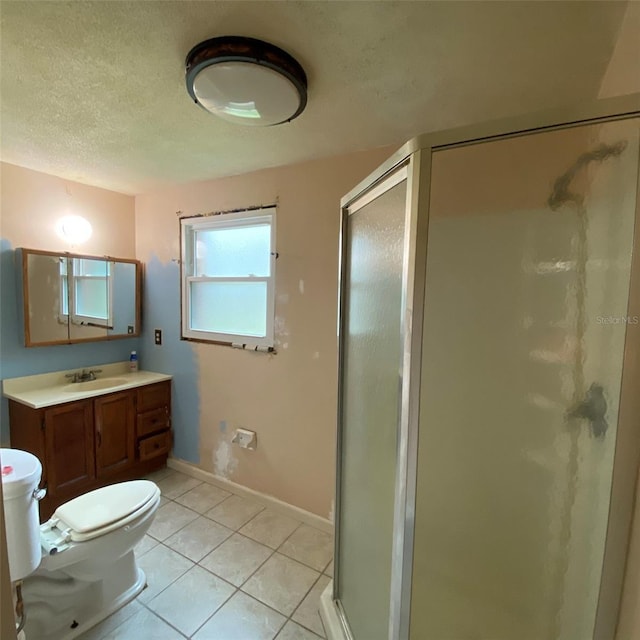 bathroom featuring tile patterned floors, a shower with door, vanity, and toilet