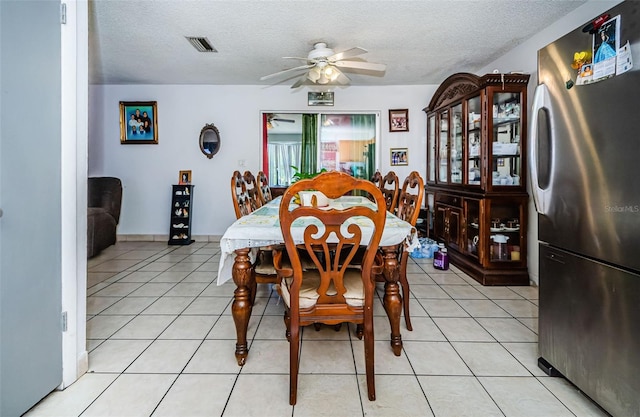 dining space with light tile patterned floors, a textured ceiling, and ceiling fan