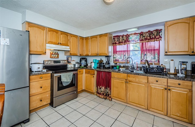 kitchen featuring light tile patterned floors, a textured ceiling, stainless steel appliances, and sink