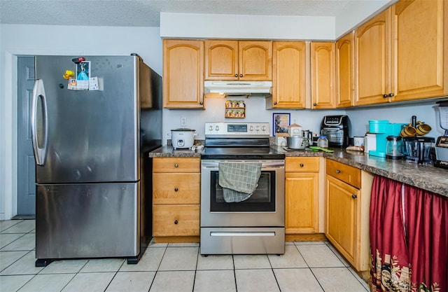 kitchen with light tile patterned floors, a textured ceiling, and stainless steel appliances