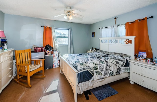 bedroom with ceiling fan and a textured ceiling