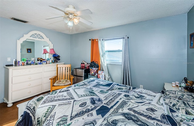 bedroom featuring wood-type flooring, a textured ceiling, and ceiling fan