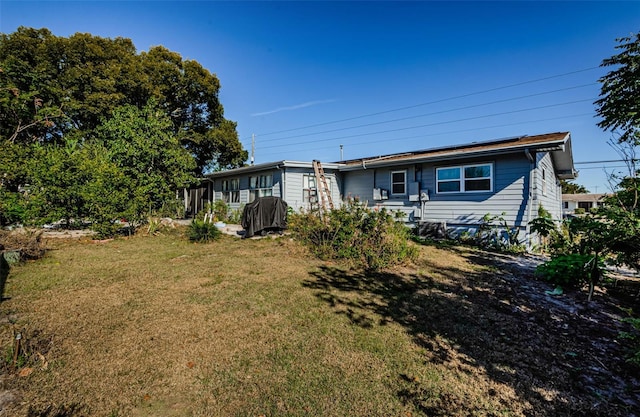 rear view of property featuring a yard