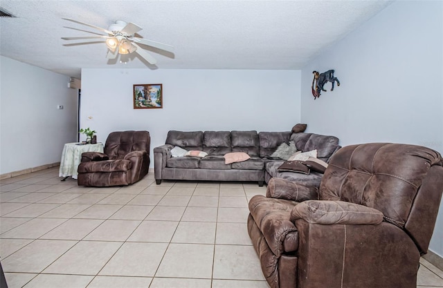 living room featuring ceiling fan, light tile patterned floors, and a textured ceiling