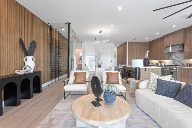 living room with ceiling fan and light hardwood / wood-style floors